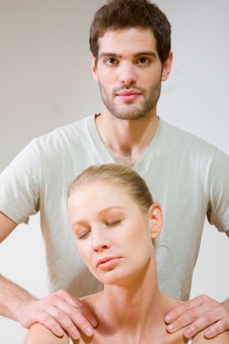 Erkek kadının omuzlarına masaj yapıyor.