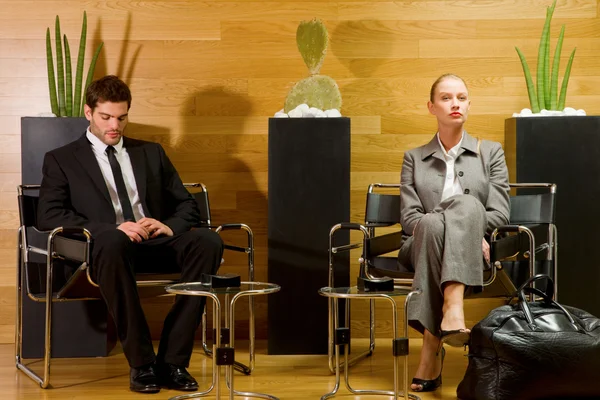Iş adamı ve iş kadını ofis lobisinde beklerken — Stok fotoğraf