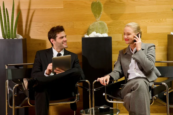 Obchodní muž a obchodní žena čeká v kanceláři lobby — Stock fotografie