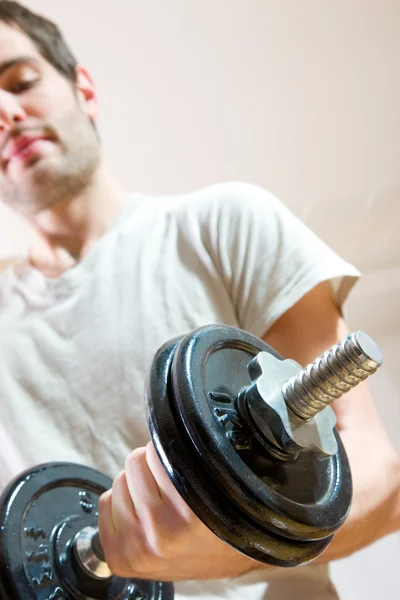 stock image Man lifting dumbbell in gym