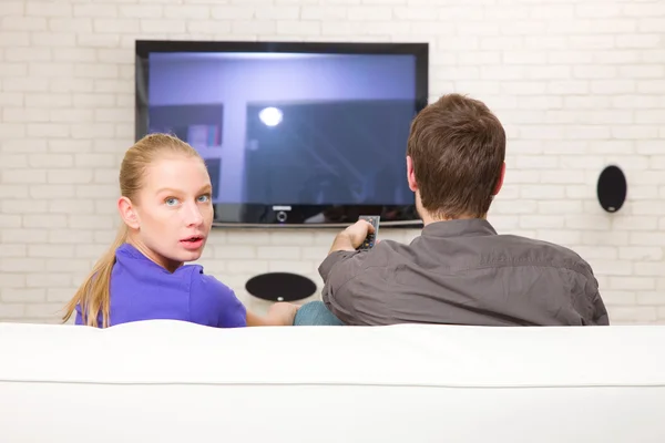 Człowiek ogląda tv kobieta patrząc wstecz — Zdjęcie stockowe