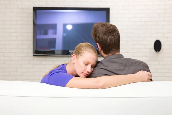 Ο άνθρωπος βλέποντας τηλεόραση γυναίκα αγκαλιάζει τον — Φωτογραφία Αρχείου