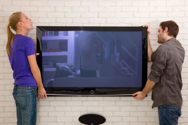 Couple hanging television — Stock Photo, Image