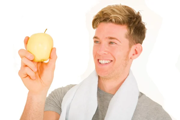Junger Mann mit einem Apfel in der Hand — Stockfoto