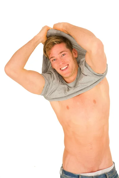 Ung man takeing av t-shirt — Stockfoto