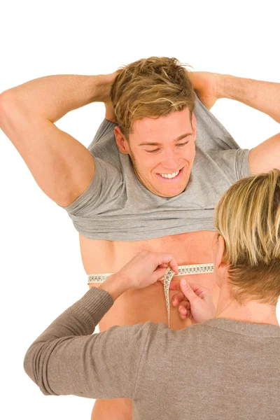 Woman measuring the chest of a young man — Stock Photo, Image