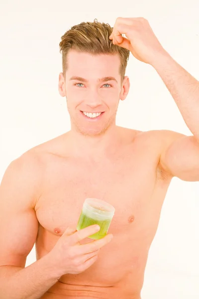 Young man applying gel on hair — Stock Photo, Image