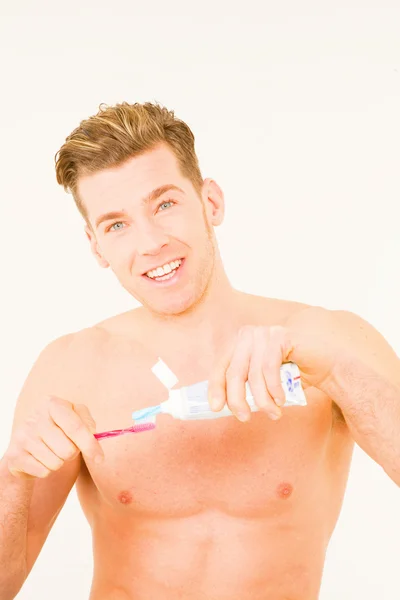 Jonge man met tandenborstel en tandpasta — Stockfoto