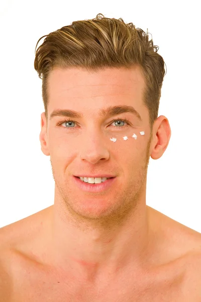 Hombre joven con crema anti-arrugas —  Fotos de Stock