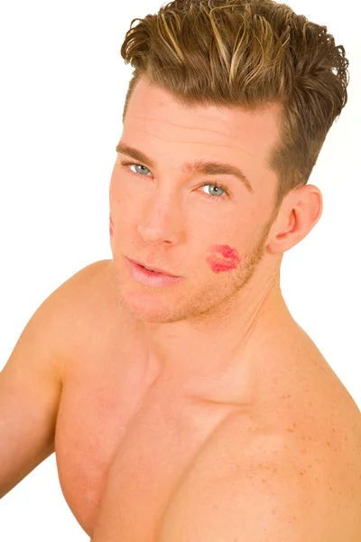 Молодой человек с отпечатком поцелуя на лице — стоковое фото