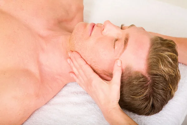 Young man receives a face massage — Stock Photo, Image
