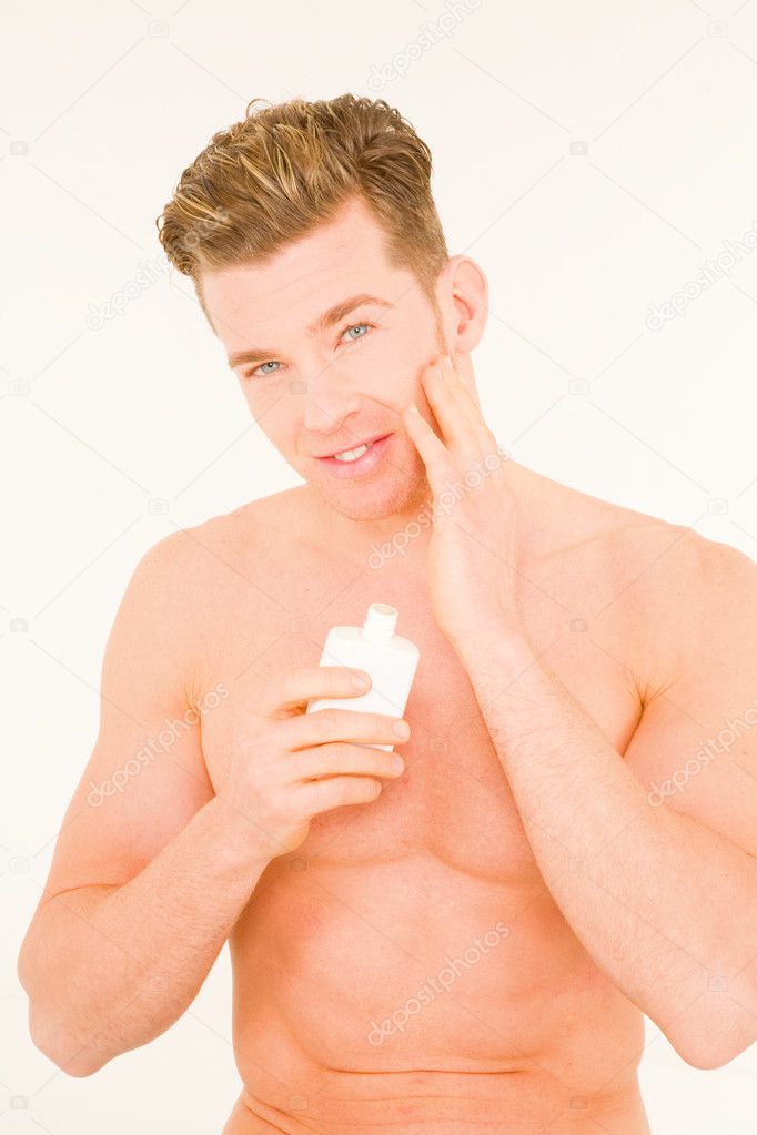 Young man applying aftershave