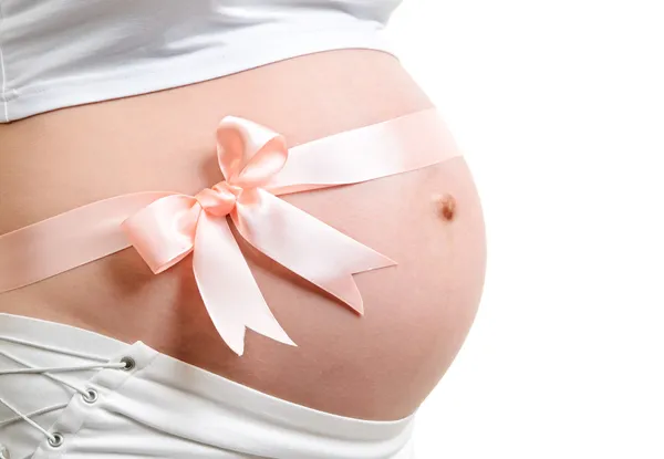 Barriga grávida com fita rosa. — Fotografia de Stock