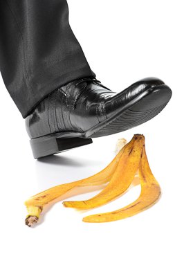 Businessman foot about to slip and fall on a banana peel clipart