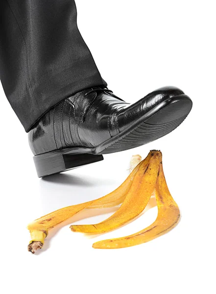 Empresário pé prestes a escorregar e cair em uma casca de banana — Fotografia de Stock