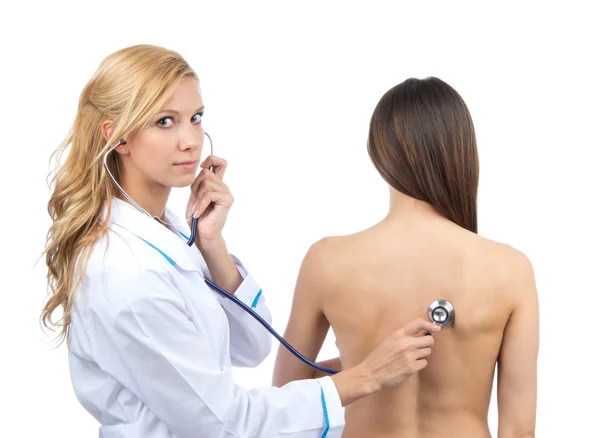 Mujer doctora auscultando a paciente joven por estetoscopio —  Fotos de Stock