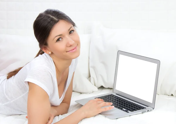 Frau liegt mit modernem Laptop auf dem Sofa — Stockfoto