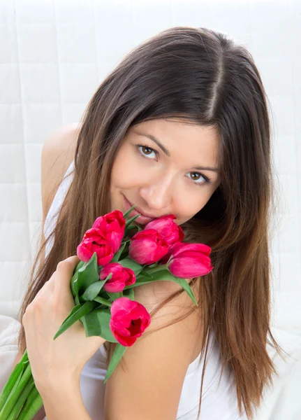 Młoda kobieta z bukietem kwiatów czerwone tulipany — Zdjęcie stockowe