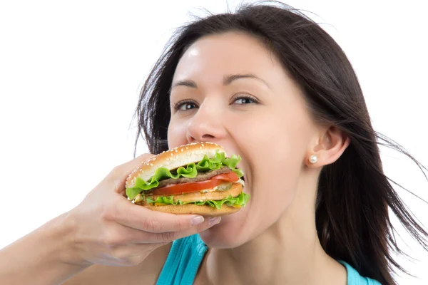Молодая женщина ест вкусный фаст-фуд нездоровый бургер — стоковое фото