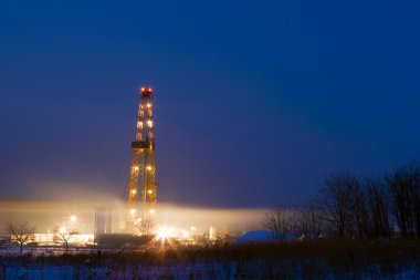 Oil well in the field illuminated at night.