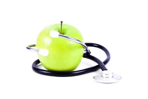 Estetoscopio médico y manzanas verdes . — Foto de Stock