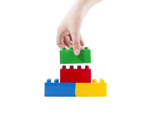 Brinquedo de construção colorido, e mão . — Fotografia de Stock