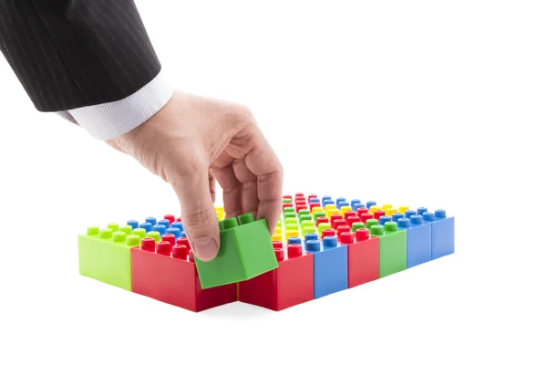 Kleurrijke hand-bouwspel en een zakenman — Stockfoto