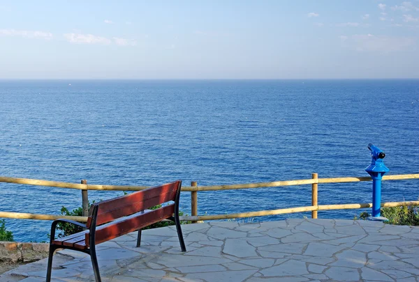 Empty bench on the seashore of Mediterranean sea. — Stock Photo, Image