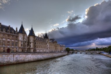 Conciergerie before rain in Paris, dramatic cloudscape. clipart