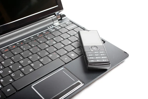 Netbook a mobilní telefon izolovaných na bílém pozadí. — Stock fotografie