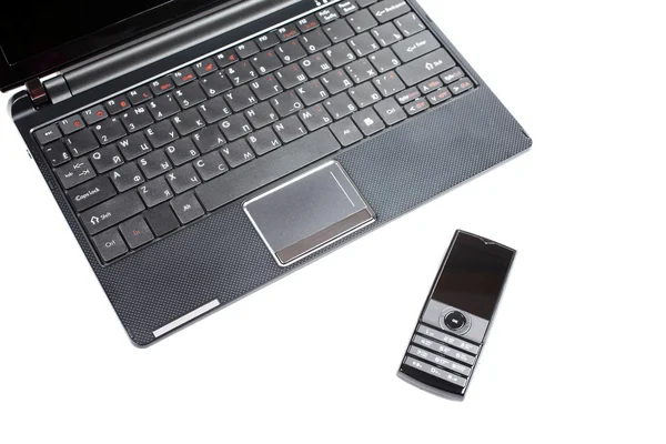 Netbook e telefono cellulare isolati sullo sfondo bianco . — Foto Stock
