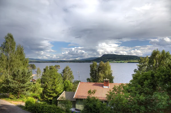 Piccola casa vicino al lago norvegese, Europa . — Foto Stock