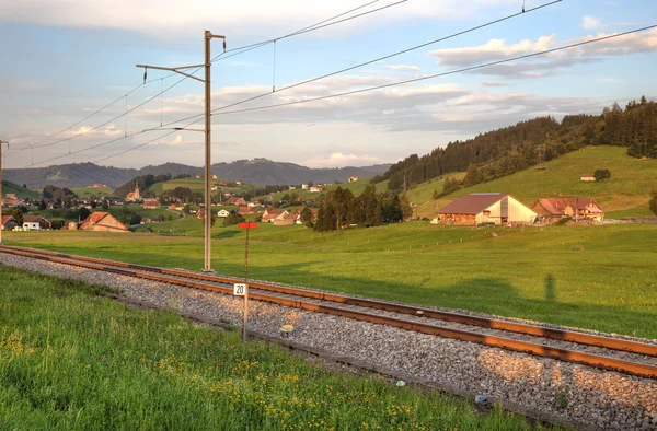 Ferrovia em Alpes Suíços antes do pôr-do-sol . — Fotografia de Stock
