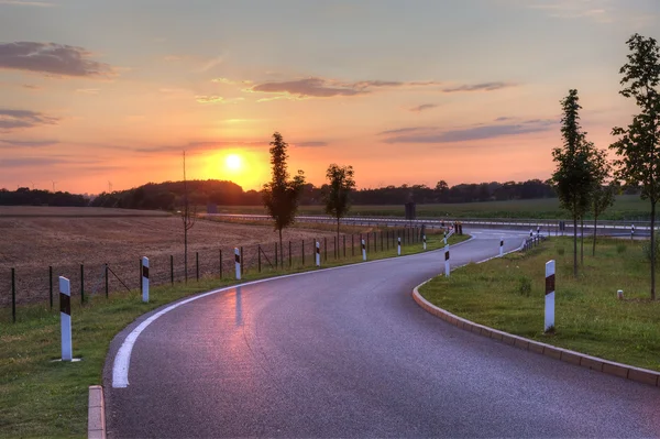 Pôr-do-sol pitoresco na estrada na Holanda, Europa . — Fotografia de Stock