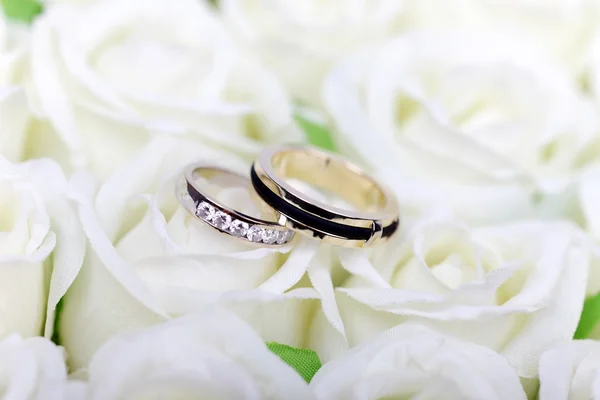 stock image Wedding engagement gold jewelry couple rings on white roses