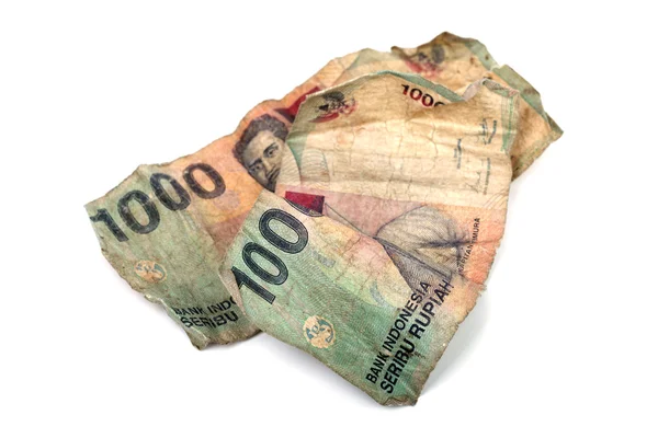 Концептуальное фото двух грязных индонезийских банкнот, изолированных на w — стоковое фото