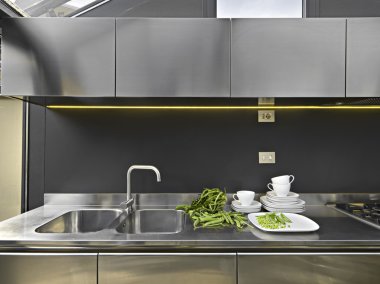 Steel sink in a modern kitchen in a attic clipart