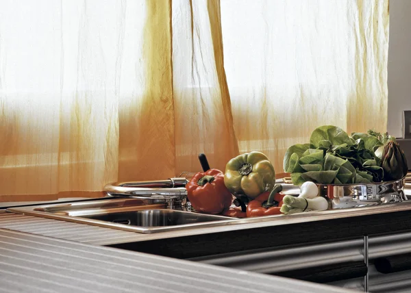 Овочі на сталевій раковині на сучасній кухні — стокове фото