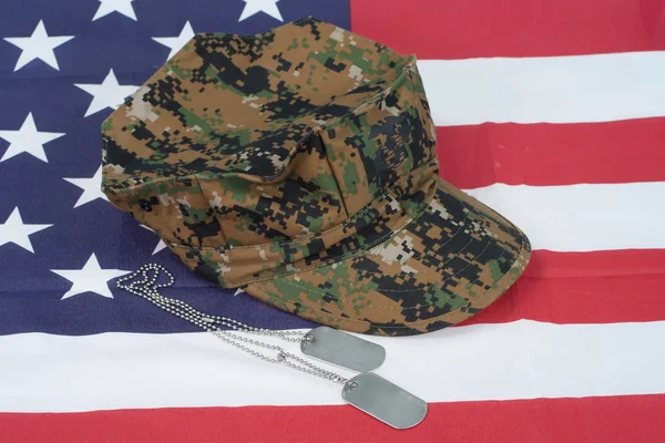 Us marine camouflage cap with blank dog tag on us flag backgroun