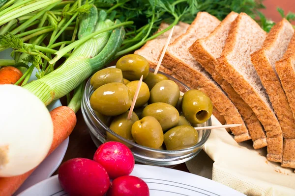 Zelené olivy, zelenina a chléb — Stock fotografie