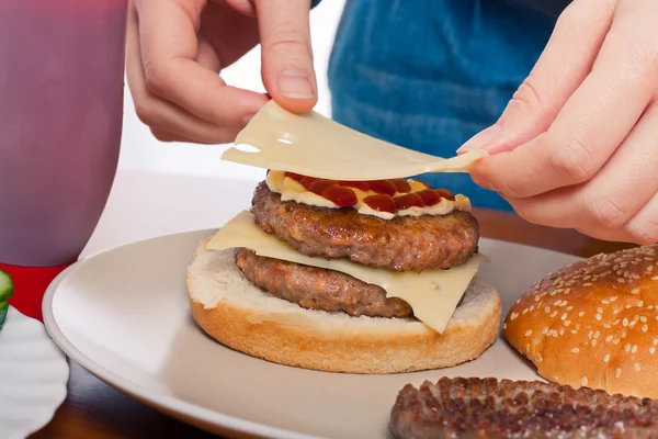 Mettere il formaggio su doppio hamburger fatto in casa — Foto Stock