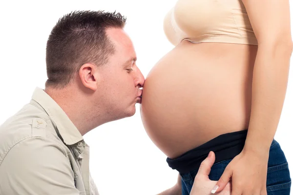 Счастливый муж целует беременный живот — стоковое фото