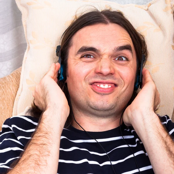 Смешной человек с наушниками слушает музыку — стоковое фото