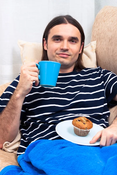 Man having breakfast on sofa — Stock Photo, Image