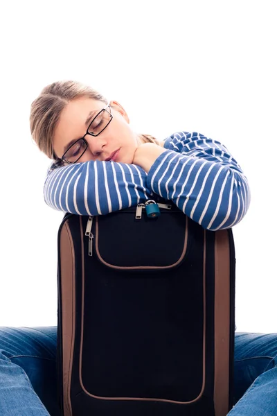 Уставшая туристка спит на багаже — стоковое фото