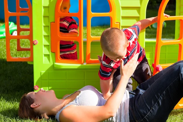 Família feliz e playhouse colorido — Fotografia de Stock