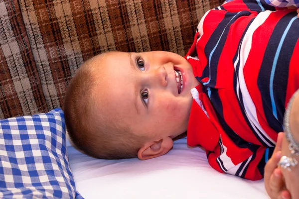 Happy child lying in the bed — Stock Photo, Image