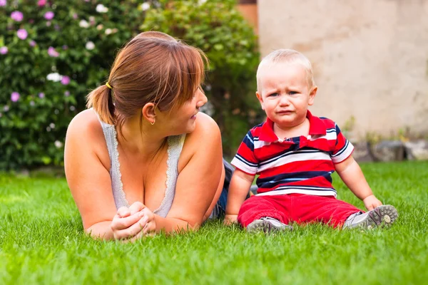 Schöne junge Mutter und weinende Kleinkind Junge im Freien — Stockfoto