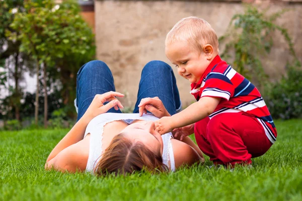Jovem mãe feliz e seu filho relaxando ao ar livre — Fotografia de Stock