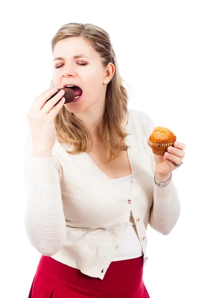 Γυναίκα απολαμβάνοντας ντόνατ σοκολάτας και muffin — Φωτογραφία Αρχείου